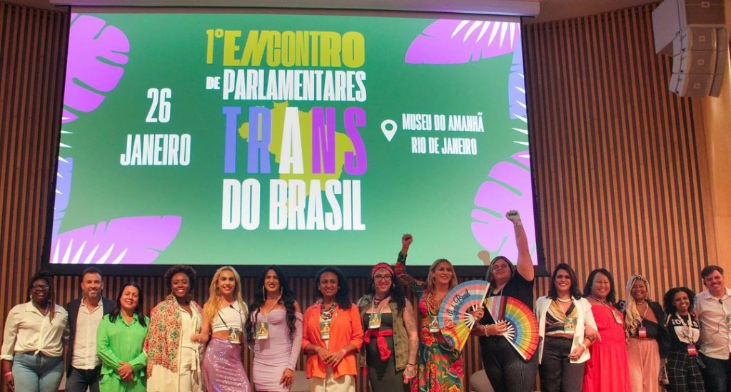 Palco do Encontro de Parlamentares Trans com pessoas e telão atrás