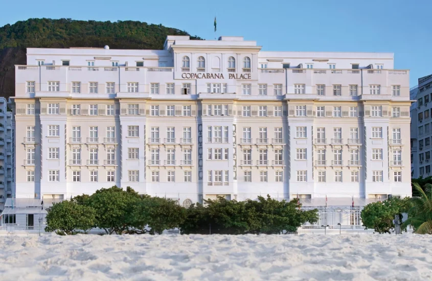 Em um final de dia, paisagem do Copacabana Palace da visão da praia com areia na frente e árvores ao redor