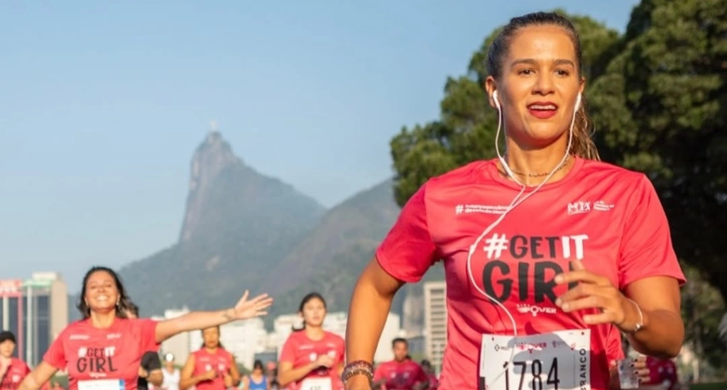 Em um dia de sol, pessoas fazendo a Corrida de Vera Cruz com paisagem das montanhas e das árvores ao redor