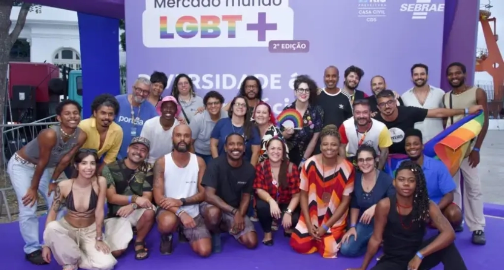 Pessoas participantes do Programa Sebrae p/ Empreendedores LGBTQIAPN+ em frente a tela roxa