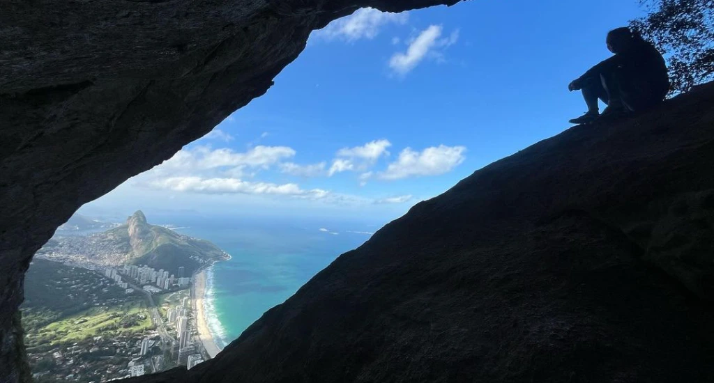 Paisagem da praia através de um buraco na Pedra da Gávea