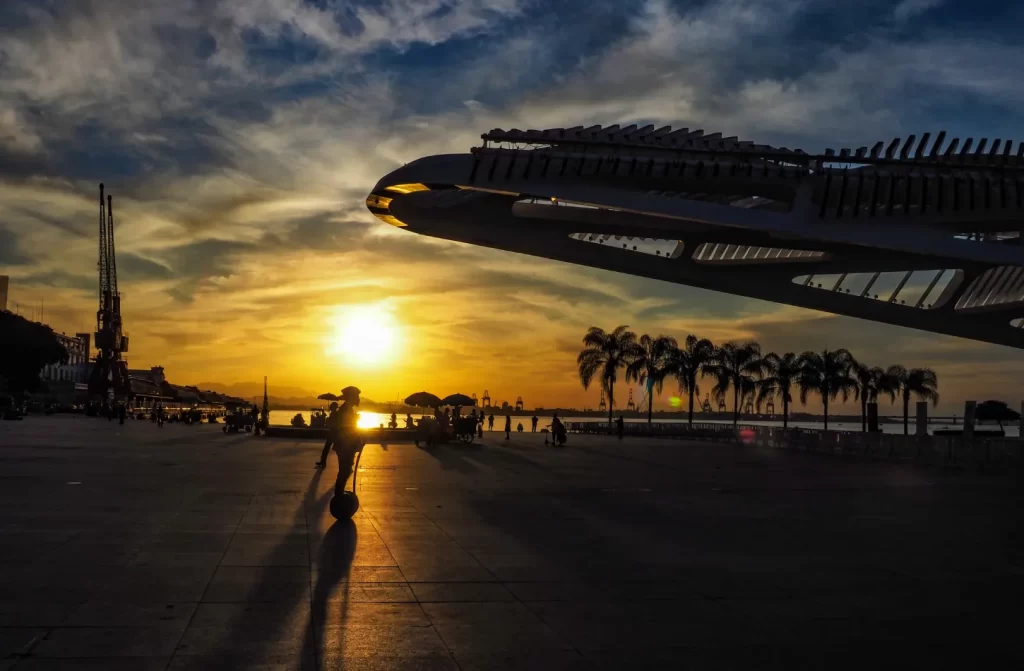 Durante o pôr do sol, Museu do Amanhã com pessoas e árvores ao redor