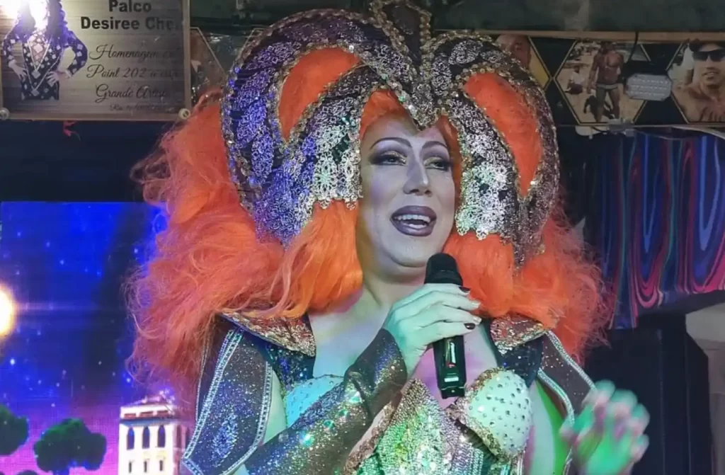 Drag queen montada de cabelo laranja com roupa decorada