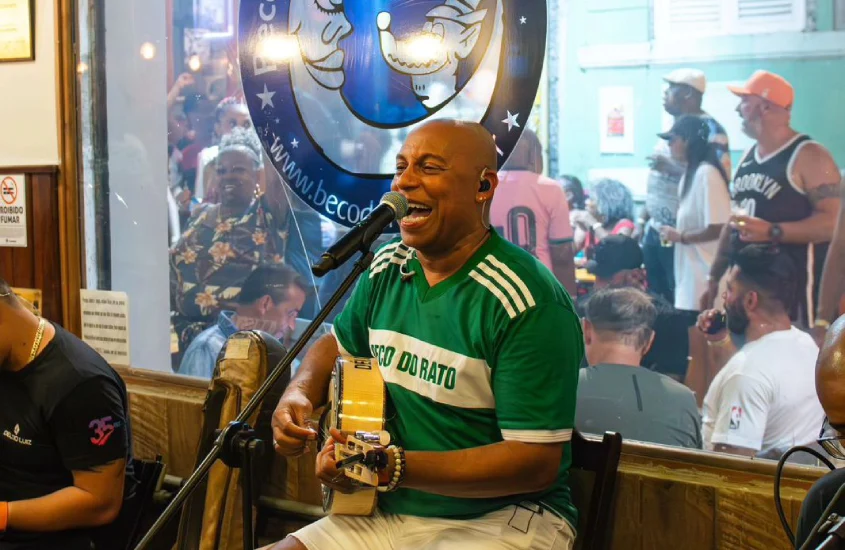 Pessoas cantando e tocando na Roda de Samba Beco do rato com público atrás