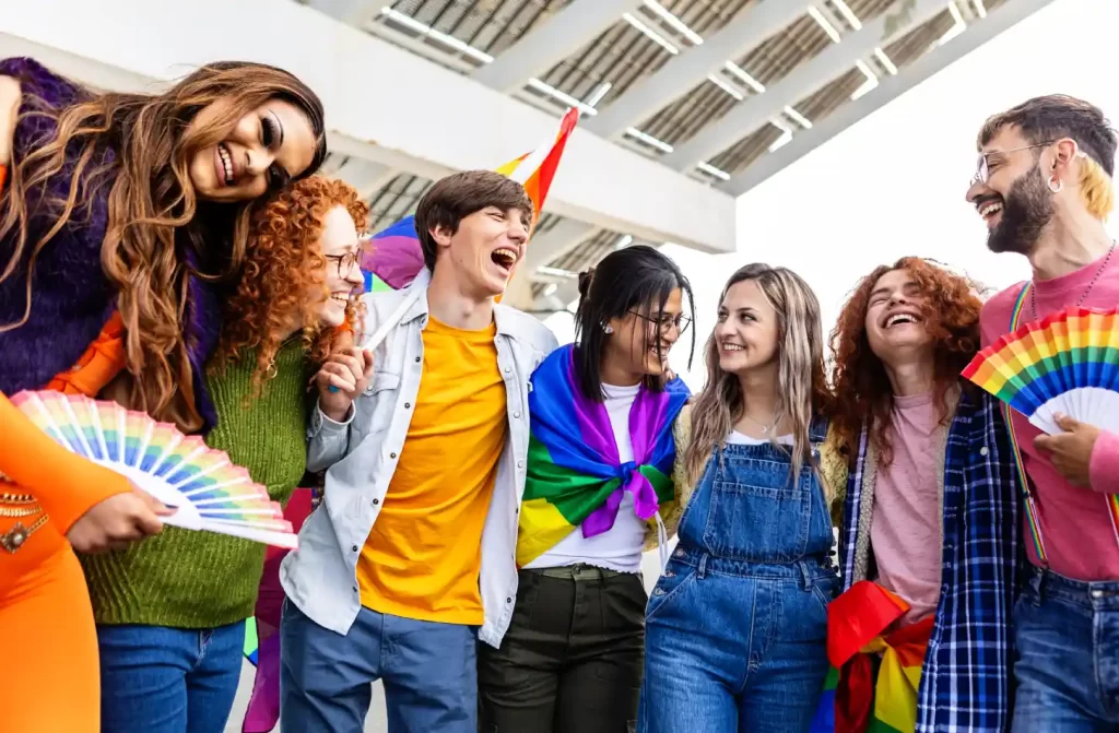 Grupo de pessoas diverso segurando leques de arco-íris