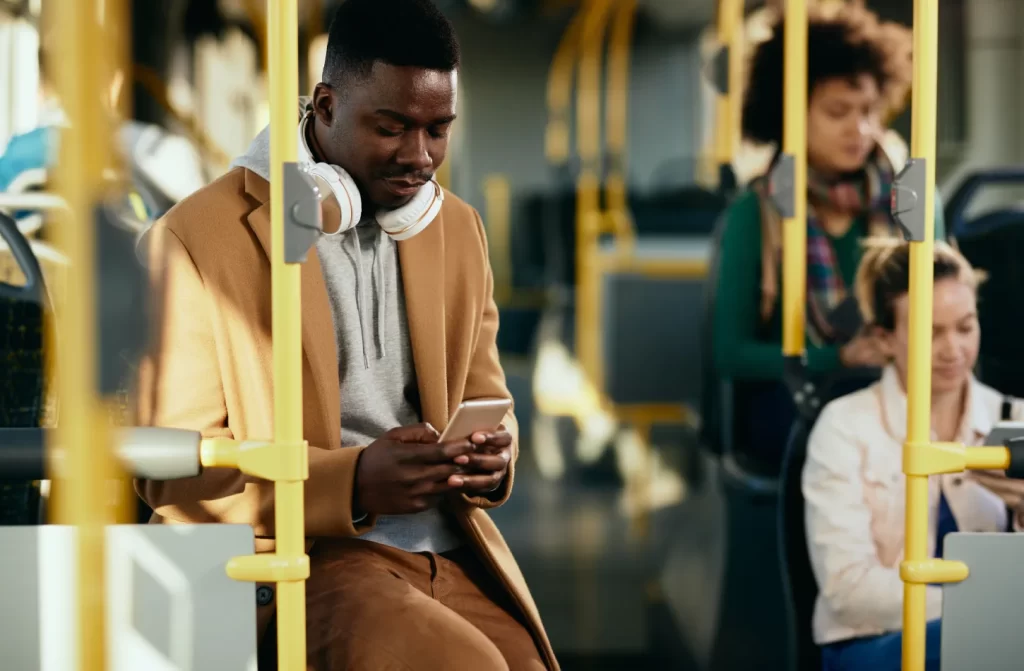 Pessoas em ônibus mexendo no celular