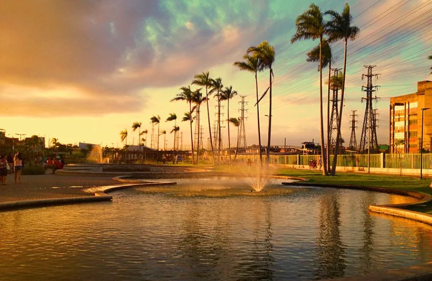 Durante o entardecer, piscinas do Parque de Madureira com árvores e chafariz