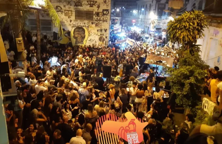 Durante a noite Samba da Pedra do Sal com muitas pessoas e árvores ao redor