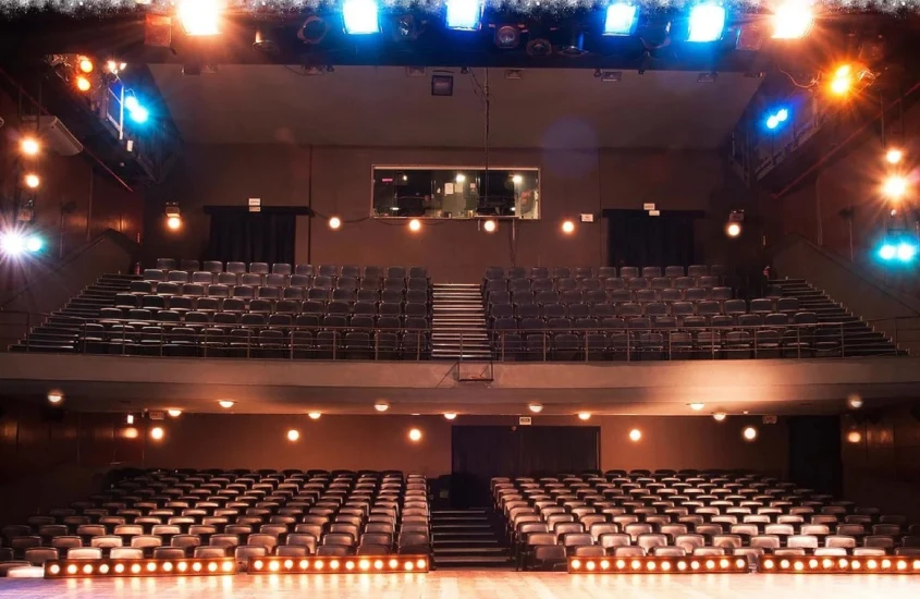 Área de plateia do Teatro Miguel Falabella com luzes brancas e amarelas