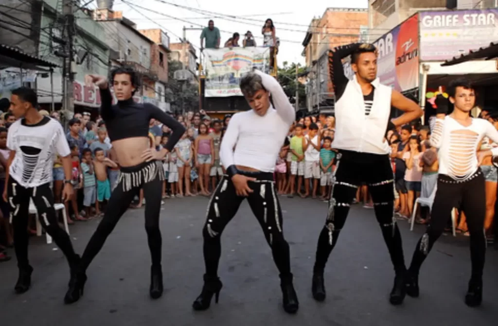 Em um dia de sol, cena de favela gay com meninos de apresentando e pessoas ao redor assistindo