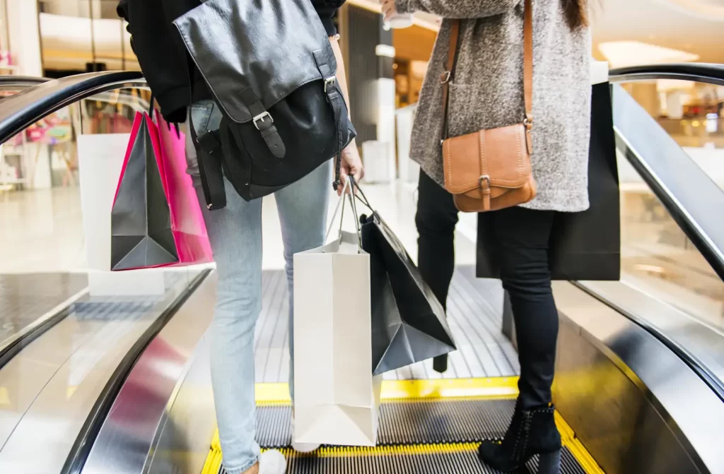 Pessoas passeando em shopping com sacolas