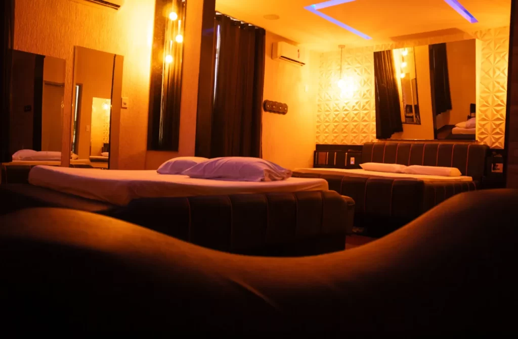 Quarto do Emoções Hotel com luzes amarelas, cama